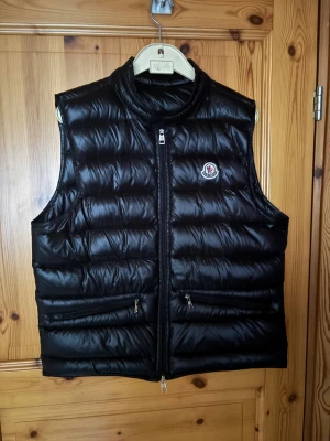 Svart dunväst från Moncler - Säljer en svart moncler gui väst i fint skick. Den är använd sparsamt då den inte riktigt passar på mig. Originaltags följer med och NFC Scan funkar som den ska. (Storlek M) pris går att förhandla