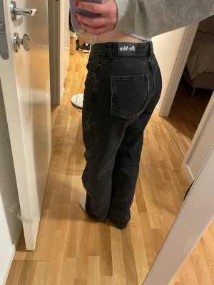 Svarta straight jeans från NAKD - Säljer ett par svarta jeans från Nakd med rak passform och mellan hög midja. Materialet är kraftigt denim i bomull och färgen är tvättad svart för en cool vintagekänsla.