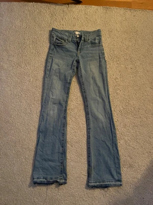 Ljusblå bootcut jeans - Säljer ett par jätte snygga ljusblå bootcut jeans från Ginatricot då de inte kommer till användning längre. Jag har sprätt upp byxorna längst ner eftersom jag tyckte de var lite för korta!