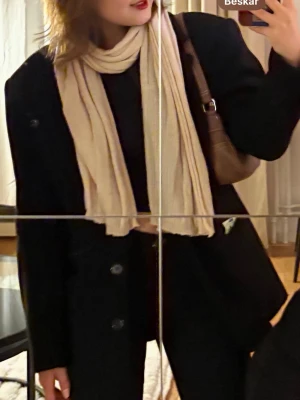 Svart ullkappa med knappar - Säljer en svart kort kappa med klassisk rak passform. Perfekt oversized look och enkel att styla till olika outfits.