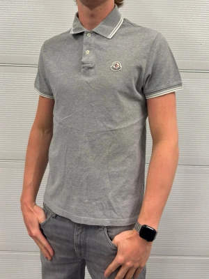 Moncler piké - En piké från Moncler i fint skick! Storlek L passar M/L. Självklart äkta. Hör av er vid frågor! Modellen är 188 och väger 77kg