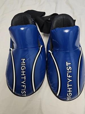 Mightyfist taekwondo skydd - Säljer ett par mightyfist taekwondo sparringskydd. Knappt använda men har några små defekter som kan ses på bilderna men inget som påverkar användningen.