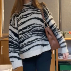 Zebramönstrad stickad tröja - Säljer en supermysig zebramönstrad stickad tröja i svart och vit. Den har en hög krage och väldigt mysig. Storleken är i L men passar mig dom bär s. Original pris är 480!!! 