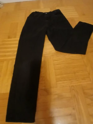 Svarta manchesterbyxor med rak passform - Snygga svarta manchesterbyxor med klassisk rak passform. Byxorna har dragkedja och knapp framtill, samt fickor både fram och bak. Materialet är mjukt och har den typiska ribbade strukturen som ger en cool vintagekänsla.