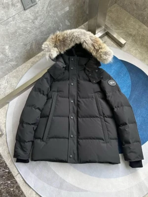 Svart dunjacka med päls från Canada Goose - Svart dunjacka från Canada Goose med fluffig päls på huvan. Jackan har lång ärm, dragkedja och knappar framtill, samt två sidofickor. Märkespatch på ärmen och quiltad design. Perfekt för kalla vinterdagar och riktigt snygg stil.