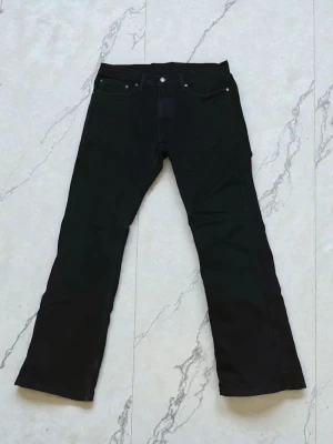 Svarta Levis 527 bootcut jeans  - Svarta jeans från Levis modell 527 med klassisk passform (W34 L32). Jeansen är helt nya, fick dem i julklapp men de passade inte så säljer vidare dem! Kontakta mig om intresse kan skicka fler bilder ifall det behövs!