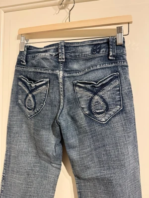 Lågmidjade blåa bootcut jeans - Supersnygga jeans med low lowaist. Broderier på fram och baksida.