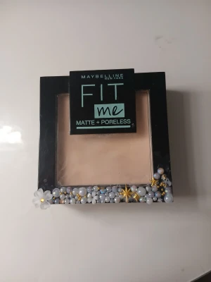 Maybelline Fit Me Matte + Poreless puder - Ganska mycket kvar💗 Säljer ett Maybelline Fit Me Matte + Poreless kompaktpuder i ljus beige nyans. Svart fyrkantig dosa med spegel och dekorerad med pärlor, blommor och stjärnor i vitt, guld och silver. Perfekt för en matt finish och jämn hudton. 