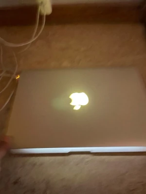 MacBook Pro - Apple MacBook Pro med bakgrundsbelyst tangentbord. Skärmen har tydliga defekter med vertikala färgstreck och skadad bild på vänster sida, men datorn startar och fungerar i övrigt. Perfekt för reservdelar eller reparation. Laddare medföljer.