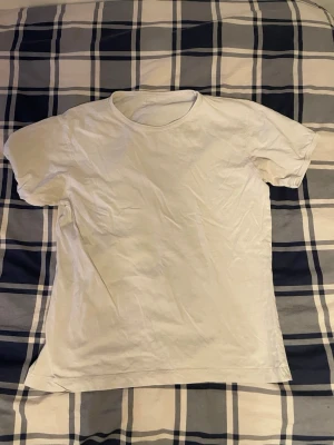 Vit basic t-shirt från Newbody - Säljer två vita basic t-shirts från Uniqlo i storlek M. De har rund hals och klassisk passform med korta ärmar. Perfekt för dig som gillar enkel och clean stil. Materialet är mjuk bomull som känns skönt mot huden.