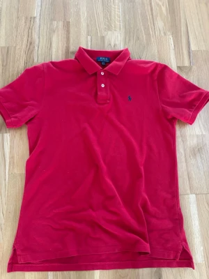 Röd pike Polo Ralph Lauren - Säljer en röd pike från Ralph Lauren. Storlek XL i barnstorlek. 