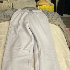 Ljusgrå mjukisbyxor från Gina Tricot - Superbekväma ljusgrå mjukisbyxor från Gina Tricot, basically basics-kollektionen. De har resår i midjan och raka ben, perfekta för chill dagar. Mjukt material och sidofickor för extra komfort.