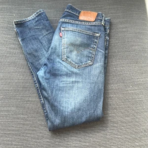 Levi's blå jeans W32 L32 - Snygga blå jeans från Levi's med väldigt snygg tvättad färg och diskret slitning på låren. Väldigt ovanlig färg. Jeansen har raka ben är perfekta nu inför hösten/vintern. Tveka inte på att fråga om ni undrar över nåt😃