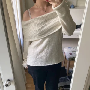 Offshoulder stickad kräm vit tröja - Superfin offshoulder stickad tröja i vit färg med bred ribbad kant upptill. Långärmad och mjuk, perfekt för lager-på-lager och chill outfits. Snygg att styla med jeans eller kjol för en trendig look.💕💕 Använd endast tre gånger ungefär💕