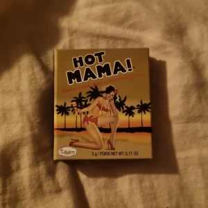 theBalm Hot Mama! rouge/highlighter - Snyggt rouge och highlighter i ett från theBalm, Hot Mama! Kommer i en kompakt förpackning med spegel. Färgen är persikorosa med guldskimmer, perfekt för att ge kinderna en fräsch glow. Innehåller 3g puder.