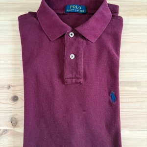 Ralph Lauren Piké - Ralph Lauren zip i röd färg med blått märke. Mycket bra skick men säljes för att den blivit för liten tyvärr. Tror det är S men passar även M mycket bra!