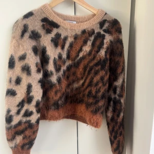 Leopardmönstrad stickad tröja XS - Fluffig stickad tröja från & Other Stories i leopardmönster med beige, bruna och svarta toner. Rund halsringning och långärmad modell, perfekt för att sticka ut i höst och vinter. Supermjuk och cozy vibe.