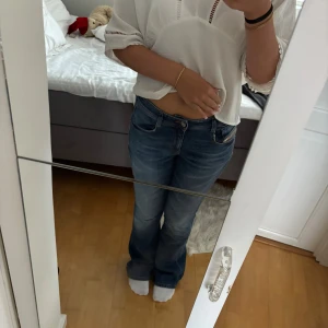 Blå bootcut jeans från Diesel - Snygga blå jeans från Diesel med klassisk bootcut-passform. Jeansen har låg midja, fem fickor och subtila slitningar för en cool look. Tillverkade i mjukt denimtyg som sitter skönt och ger en avslappnad vibe.