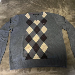 Tommy Hilfiger tröja - Blå tröja från Tommy Hilfiger i storlek L, passar även M med argylemönster i mycket fint skick. 