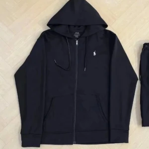 Svart hoodie från Polo Ralph Lauren - Svart hoodie från Polo Ralph Lauren med dragkedja och huva. Klassisk logga broderad på bröstet och snörning i huvan. Tillverkad i mjuk bomull, perfekt för chill dagar. Stora fickor framtill och ribbade muddar vid ärmslut och nederkant. Passar för både M och S