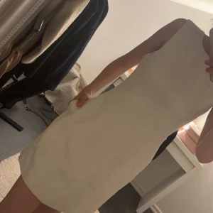 Vit strukturerad ärmlös klänning - Snygg vit kortklänning med strukturerat tyg och ärmlös design. Klänningen har en figurnära passform, rund halsringning och dragkedja i ryggen. Perfekt för dig som gillar stilrena och eleganta plagg med lite extra textur. Klänningen har fickor 