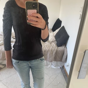 Svart topp från Filippa K - Svart topp från Filippa K med snygga lite puffig och trekvartsärm. Modellen är unik, figurnära och har rund halsringning. Materialet är skönt och mjukt. 💕