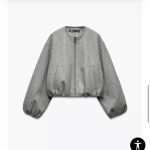 Grå bomberjacka från Zara - Säljer en grå croppad bomberjacka från ZARA med rund halsringning och dragkedja framtill. storlek L men sitter som S tog L då jag ville ha den lite längre. Perfekt för dig som gillar minimalistisk stil. använd en gång så den är som helt ny