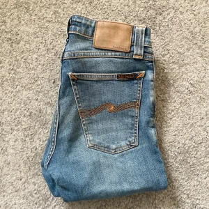 Nudie Jeans - Sjukt snygga jeans från märket Nudie Jeans | Sjukt snygg färg, väldigt eftertraktade | Skick 7/10 - enda felet är att ena fickan är trasig (som du ser på bilden) | Storlek W26 L32 | Jag kan gå ner i pris ‼️Kom gärna med bud och hör av dig vid minsta lilla fråga.
