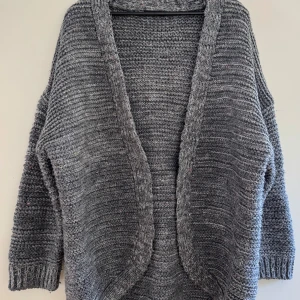 Grå stickad kofta från Zara - Mysig och oversized grå stickad kofta från Zara med öppet framtill och breda ribbade muddar. Perfekt att slänga över en t-shirt när det är kyligt ute.