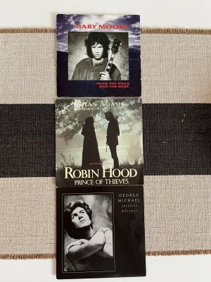 Tre sällsynta singelskivor - Tre klassiska vinylsinglar med ikoniska låtar från Gary Moore, Bryan Adams och George Michael. Perfekt för dig som älskar retro, samlar på musik eller vill upptäcka legendariska hits på äkta vinyl. Skapa nostalgiska vibbar och maxa din musiksamling!