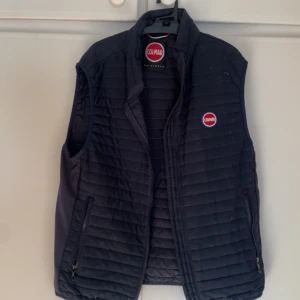 Colmar väst  - Blå Colmar Väst, väldigt fin men luddar i tyget. Sitter som en S/M.