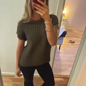 Stickad topp - Så fin! Stickad topp som är superskön och sticks ej. Den har vita detaljer längst ut på armen 