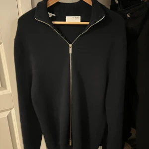Mörkblå kofta/tröja - Svart stickad tröja från Selected Homme som är hel zip. Materialet är mjukt och tröjan är perfekt för kallare dagar. Tröjan har använts fåtal gånger så är i näst intill ny skick. Tröjan ligger på 800kr nypris.
