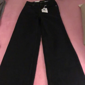 Svarta wide jeans  - Säljer ett par svarta jeans från Tower Wide i modellen wide leg. Byxorna har klassisk femficksdesign, hög midja och är tillverkade i Fairtrade-certifierad bomull. Perfekt för dig som gillar en avslappnad och trendig look. Dom är helt nya och aldrig använt, säljer dom för 500 istället för 600.( pris diskuteras)