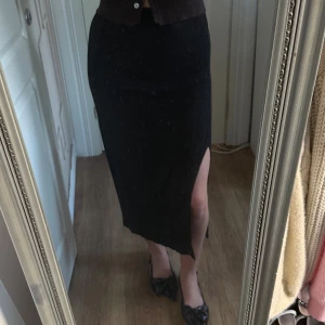 Svart ribbad långkjol från NA-KD - Säljer en svart långkjol från NA-KD i ribbat material. Kjolen har en tight passform och en snygg slits på sidan. Materialet är väldigt skönt och ganska tunt🖤