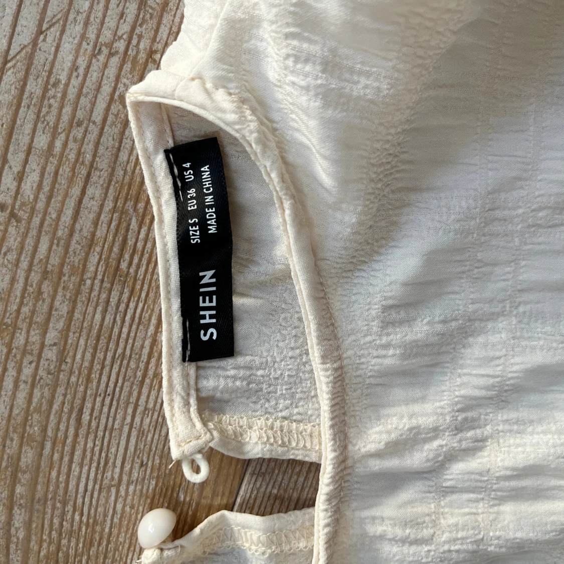 Vit topp med rynkdetaljer och volanger - 3