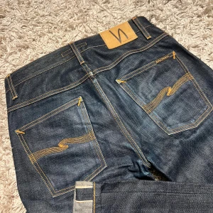Dry Selvedge nudie jeans modell grim tim slim striaght fit - Dry Selvedge nudie jeans modell grim tim i slim striaght passform. Nytt skick inga defekter, riktigt najs material. Storlekslappen är tyvärr klippt men sitter som w30 passar 31 också, 100% organic cotton. Postas antigen samma dag som köp eller dagen därpå🙌💯