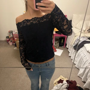 Off shoulder topp - Säljer en snygg marinblå off shoulder topp i spets från H&M. Strl S men passar även xs. Lappen sitter tyvärr inte kvar. (Tröjan ser svart ut men färgen framkommer lite bättre på sista bilden)