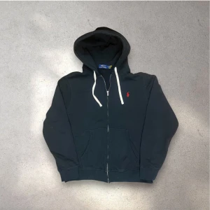 Svart hoodie från Polo Ralph Lauren - Svart hoodie från Polo Ralph Lauren med vit snörning i huvan och röd logobrodyr på bröstet. Mycket bra skick✅ skickar snabbt efter att du har beställt📦😁