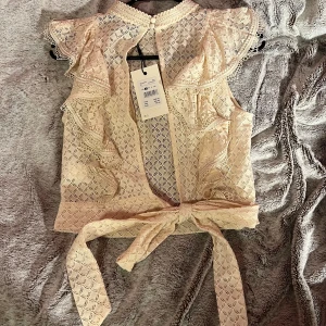 Volangtopp med öppen rygg  - Otrolig fin Volangtopp med öppen rygg som man knyter 😍 helt ny med prislapp, köpt för 399 men tyvärr aldrig använt den så dags att sälja 🫶