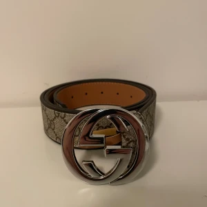 Beigt bälte med silver spänne - Säljer ett helt nytt bälte den är inte använd en ända gång och det finns inga fel på den storlek 115 cm