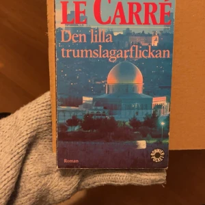 Den lilla trumslagarflickan - En spännande roman om Charlie, en ung skådespelerska som dras in i en värld av spionage och konflikter mellan Israel och Palestina. Perfekt för dig som gillar thrillers med starka karaktärer och dramatiska vändningar. Skriven av mästaren John le Carré.
