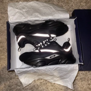 Svarta Dior sneakers med reflekterande detaljer - Säljer ett par svarta Dior sneakers med chunky plattformssula och reflekterande silvriga detaljer. Helt nytt och oanvänd.