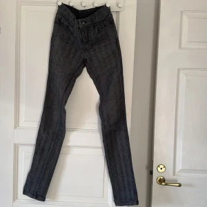 Grå jeans från Dr Denim - Säljer ett par grå jeans från Dr Denim med klassisk femficksdesign och raka ben. Jeansen har normal midja och är tillverkade i ett mjukt bomullsmaterial med lite stretch. Perfekta för dig som gillar en stilren och enkel look. Långa och smala