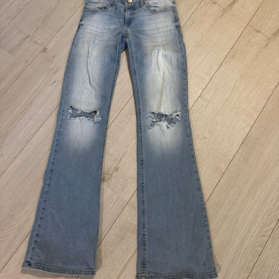 Ljusblå bootcut jeans med slitningar