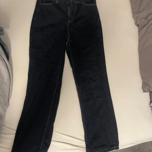 Straight legg Mörkblå high waist jeans Fashion Nova - Snygga mörkblå jeans från Fashion Nova med hög midja och raka ben. Klassisk femficksmodell med kontrastsömmar och dragkedja. Tillverkade i en stretchig mix av bomull, polyester och spandex för skön passform.