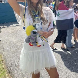 Vit kort studentklänning med volang - Säljer min supersöta vita  studentklänning med volang. Klänningen har puffiga korta ärmar i transparent tyg och en v-ringad omlott upptill. Perfekt för student eller sommarens festligheter. Materialet känns lätt och luftigt. Använd en gång under studenten 🤗