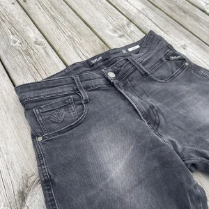 Replay svarta jeans - Snygga svarta jeans från Replay med diskret tvättad look och klassiska fem fickor. Modellen heter anbass och storleken är W30 och L32!