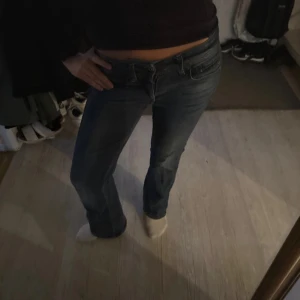 G star jeans - Säljer ett par klassiska blå jeans med bootcut och låg midja. Jeansen har fem fickor, dragkedja och knapp framtill. Snygg passform som sitter tajt upptill och släpper ut vid benen. Perfekta för en avslappnad och trendig look.