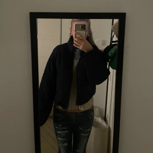 Mörkblå kort pufferjacka - Säljer en svart pufferjacka med hög krage och dragkedja framtill. Jackan är kortare i modellen och har en oversized passform med långa ärmar. Perfekt för kalla dagar. Säljer pga den inte används längre, skriv vid frågor eller intresse 🥰
